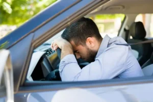 Zabrinut čovek sedi u automobilu koji nije prošao tehnički pregled.